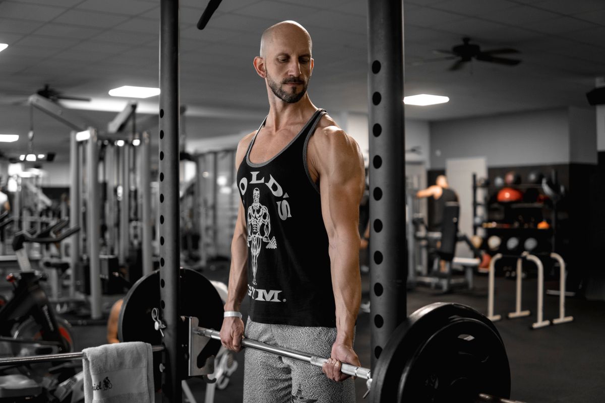 Best muscle-building exercises: choose your workout menu | the gym pro Man Holding A Barbell In A Gym