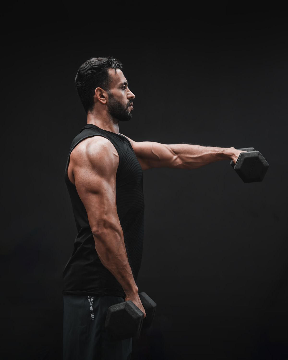 Shoulder workout: presses, lateral raises and rear delts | the gym pro Man Raising A Dumbbell In Front Of His Body