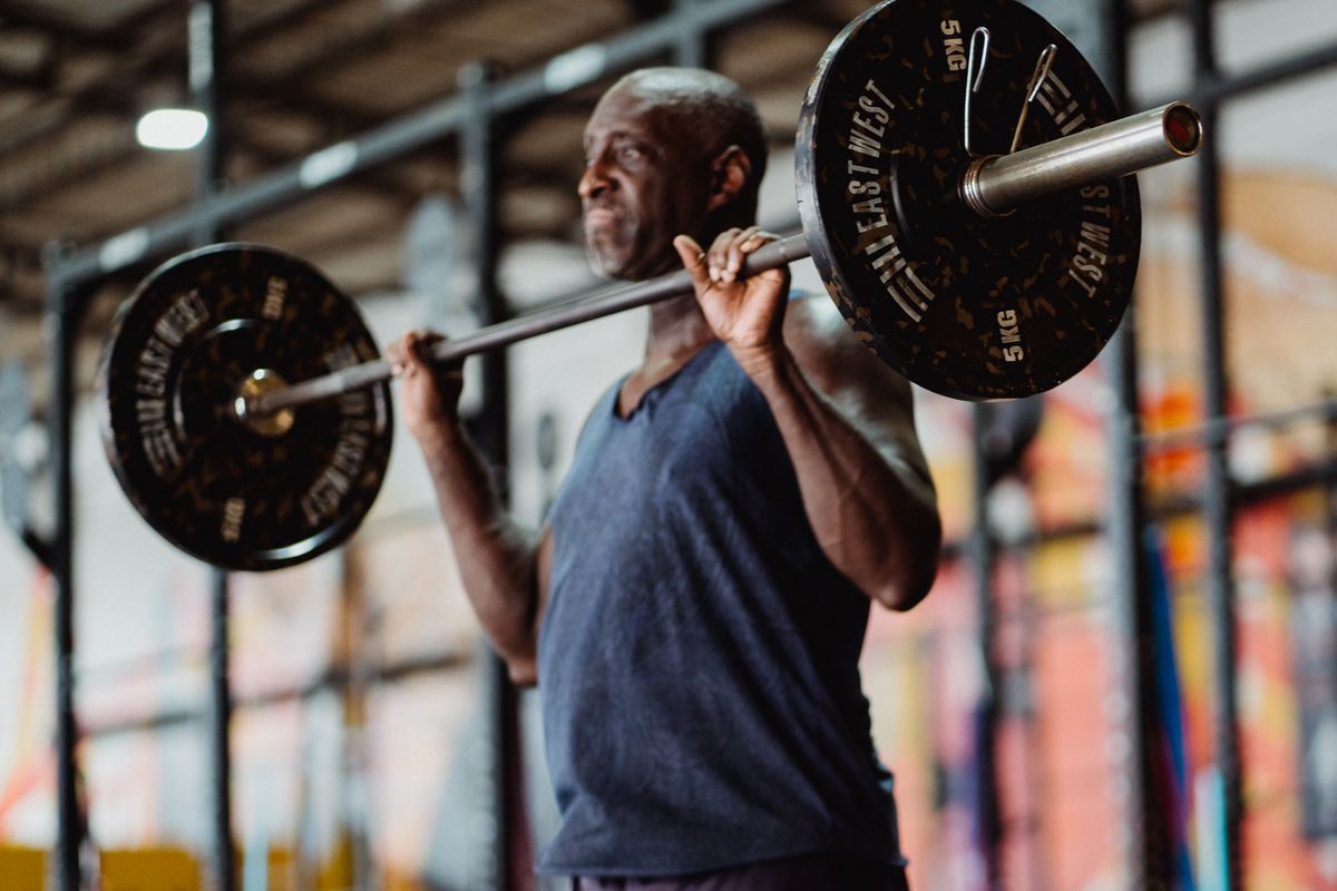 Best rep range for muscle growth: how to choose yours | the gym pro Lifter Holding A Barbell In The Front Rack Position